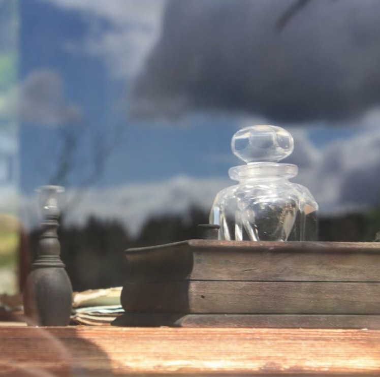 Mesa de estudio con frasco y paisaje reflejado